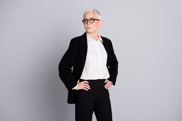 Photo portrait of pretty senior female professional entrepreneur look empty space wear formalwear specs isolated on gray color background