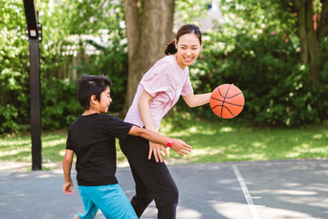 Basketball, family and teaching sport with a mom and son training on a court outside for leisure fitness and fun