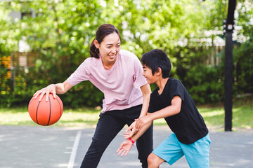 Basketball, family and teaching sport with a mom and son training on a court outside for leisure...