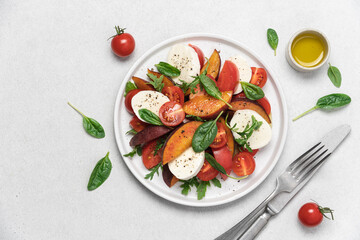 Peaches, tomatoes, mozzarella salad in plate on  white background. Caprese italian traditional salad top view