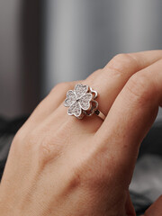 A ring in the shape of a four-leaf clover with precious stones on the finger. An elegant decoration that emphasizes style and luxury.