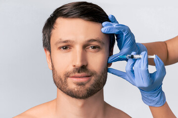 Male Injective Cosmetology. Middle Aged Man Receiving Wrinkle-Removing Injection Over White Studio...