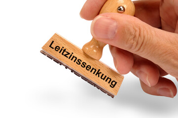 Ein Holzstempel ist beschriftet mit dem Aufdruck: Leitzinssenkung