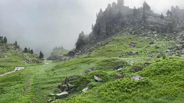 Une petite rivi&egrave;re serpente &agrave; travers une plaine de montagne, entour&eacute;e de sommets majestueux. L'eau scintille sous le ciel clair, offrant un contraste paisible avec les montagnes environnantes.