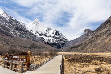 Boardwalk in the scenic and breathtaking Yading nature reserve's Luorong Pasture grassland in Sichuan. Chinese words on board translated to English as Luorong Pasture SIghtseeing Bus Center.