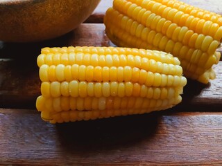 Cut and cooking corn and wooden background