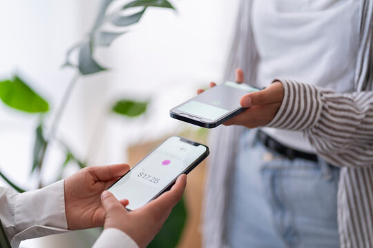 Two people engage in a digital payment transaction using their mobile phones The phones are close together, highlighting the ease of electronic transactions