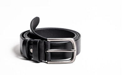 Twisted black leather belt with matted metal buckle isolated on white background. Fastened fashionable unisex, man or woman accessory for trousers, jeans, dress. Male luxury strap. Haberdashery goods