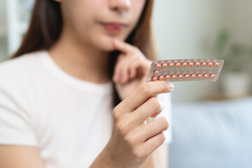 young female holding birth control pills