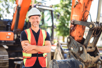 caucasian engineer with white helmet at work and having a mechanical shovel on the back