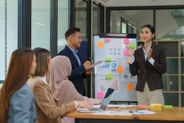 A group of business people is having a meeting at a tech company. Creative business professionals planning a project in an office. Teamwork and collaboration in a modern workplace.