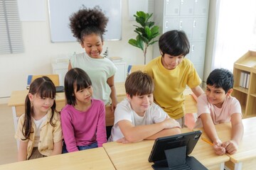 A group of diverse elementary school students are gathered around a tablet, engaged in an interactive learning activity.