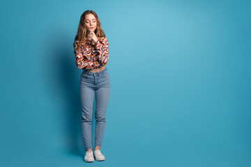 Full length portrait of nice young girl look down empty space wear top isolated on blue color...