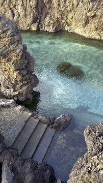 Pools formed by volcanic lava, naturally filled with sea water. Porto Moniz, Madeira island, Portugal.  Stone steps into the water
