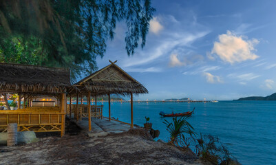 Colourful Skies Sunset over Rawai Beach in Phuket island Thailand. Lovely turquoise blue waters, lush green mountains colourful skies and beautiful views of long tail Boats