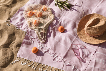 Straw hat, sunglasses, towel, bag on beach sand background. Aesthetic lifestyle, summer vacation concept. Sunbathing, beach party set, holiday picnic. Travel fashionable blog, social media, top view.