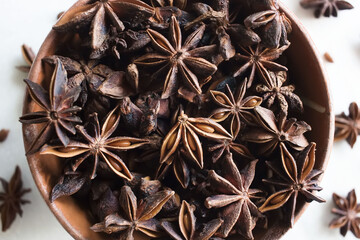 Dry star anise and anise seeds in clay bowl