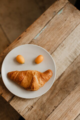 Croissant auf einem Teller auf einem Holztisch