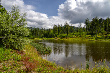 View of the Olza reservoir with reflections in the water on a hot summer day