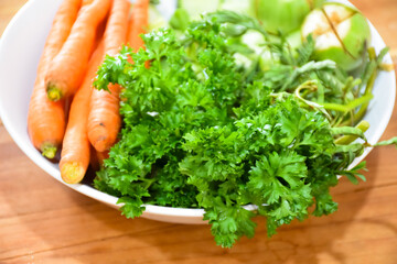 Healthy food: Fresh vegetables rosemary, carrots, brinjal and cucumber in a white ceramic plate.