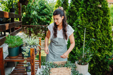 Young woman taking care of plants with water can and mister