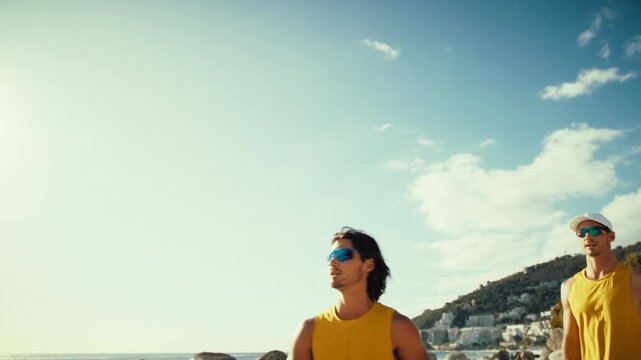 Wide angle handheld action shot of professional male Australian beach volleyball players