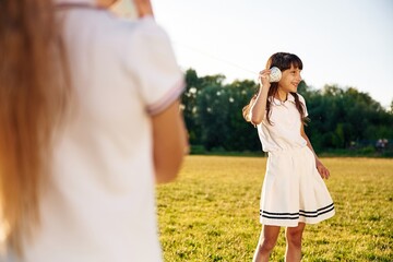 Naklejka premium Fun, with tin can phone. Happy kids are on the summer field