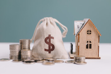 House, saving gold coins and bag with dollar sign, money invest on real estate property concept....