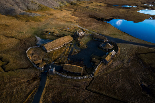 Aerial view of Viking village, buildings, pond, grassland, and mountains, Stokksnes, Hornafjordur, Iceland.