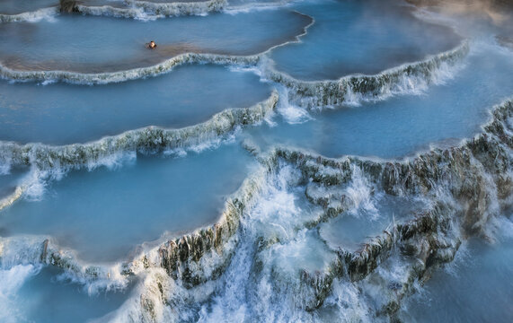 Aerial view of tranquil thermal springs with misty morning mist, Terme di Saturnia, Tuscany, Italy.
