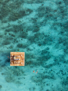 Aerial view of swimmers on floating platform in crystal clear Caribbean Sea, Westpunt, Curacao.