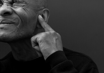 deaf man suffering from deafness and hearing loss on grey background with people stock image stock photo	