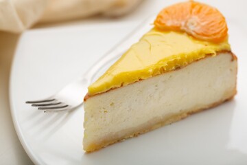 Delicious orange cheesecake with cream on plate