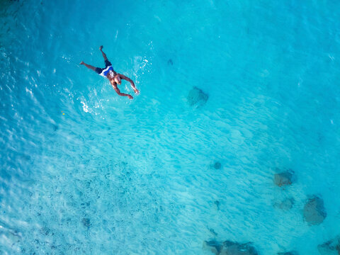 Aerial view of crystal clear Caribbean sea with one person swimming, Westpunt, Curacao.