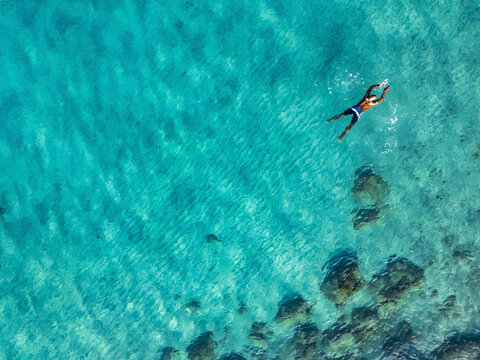 Aerial view of crystal clear Caribbean sea with one person snorkeling, Westpunt, Curacao.