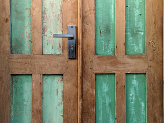 An old wooden door exudes timeless charm with faded paint texture.