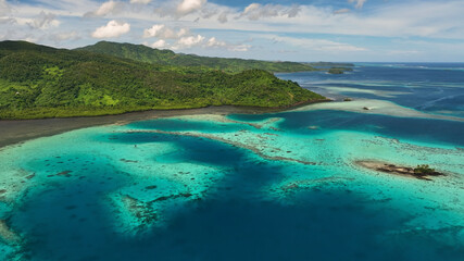 Aerial view of tropical island with reef and clear turquoise water, Fiji.