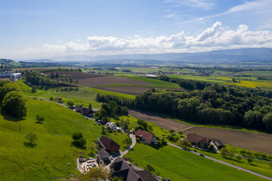 Aerial view of picturesque village life surrounded by lush greenery and rolling hills, Schupfen, Switzerland.