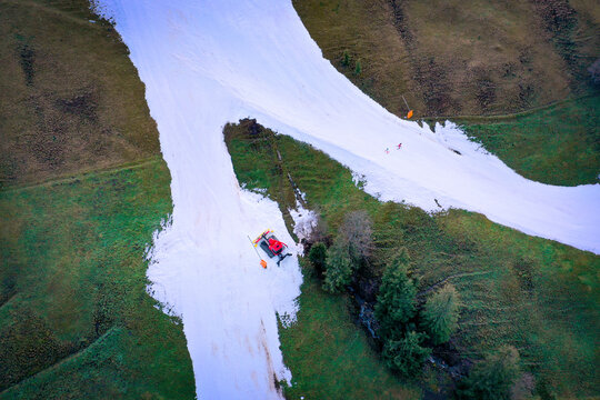 Aerial view of snowy ski slopes and lush green grass in Sorenberg, Lucerne, Switzerland.
