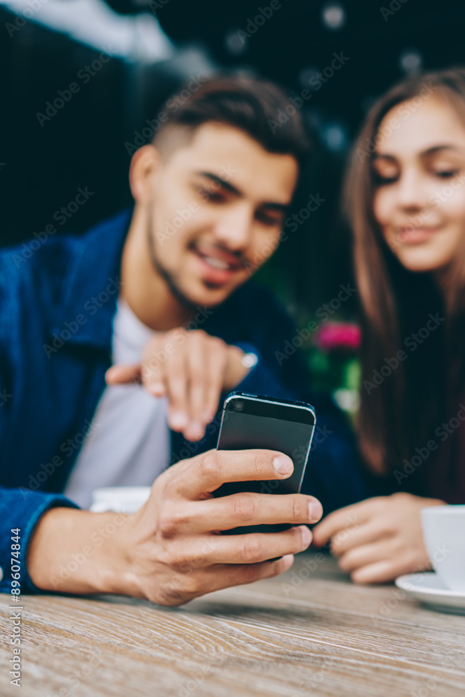 Poster selective focus on smartphone in hand of hipster guy using gadget for showing multimedia files to hi