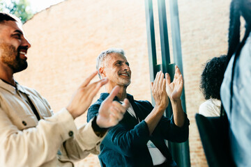 Workers clapping at a seminar, displaying teamwork and encouragement