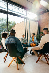 Team talking and communicating in an office setting with chairs arranged in a circle