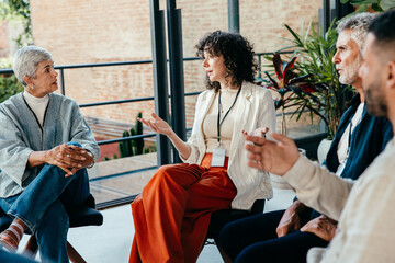 Group of diverse people talking in a casual office meeting in a modern workplace