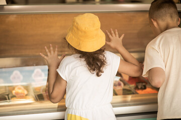 Cute girl and teenager boy buy waffles with ice cream and milkshake in cafe.