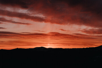 Obraz premium Stunning Red Sunset Over Mountain Landscape