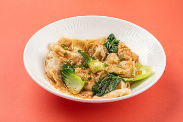Portion of appetizing asian wonton dumplings with bok choi