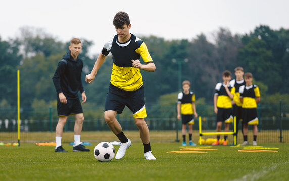 Teenage Boys Training Sports . Soccer Summer Camp for Young Boys. Happy Football Players on Practice Session. Youth Team Kicking Balls on Turf Pitch. Soccer Training Trail With Equipment