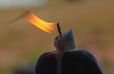 a lit candle on top of a rock