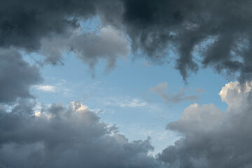 Dramatic sky background with dark rainy clouds at sunset.
