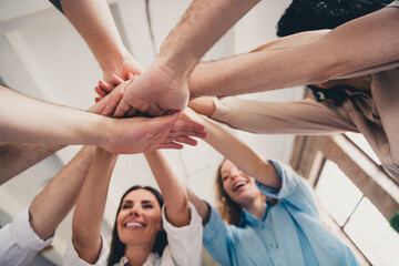 Cropped portrait of group professional corporate workers pile stack hand shake loft interior business center indoors